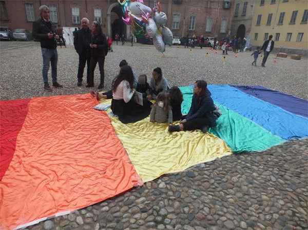 I bambini ascoltano le favole seduti sui ciottoli della piazza dopo essere stati cacciati dai gradini della chiesa